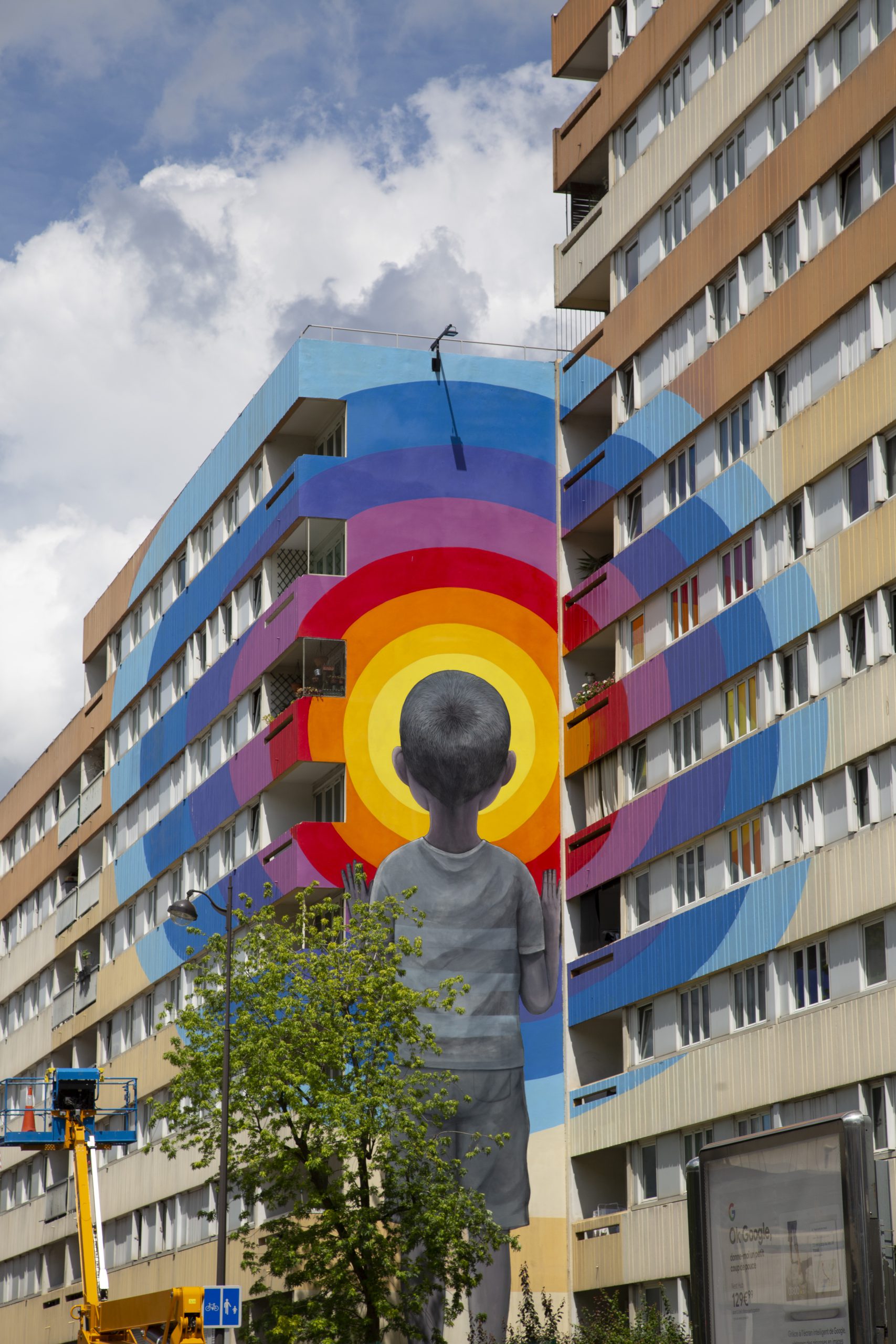 Œuvre murale en trompe l'œil, représentant un enfant de dos devant une multitude de cercles colorés et concentriques.